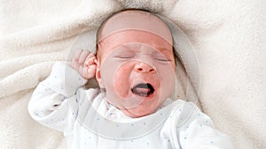 Top view closeup shot of newborn baby boy crying beacuse of feeling hungry