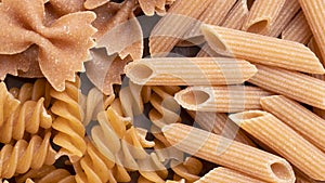 Top view, closeup of whole wheat farfalle, penne and fusilli pasta