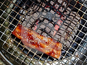 Top view of a cocked piece of meat on round metal grill on Japanese Yakiniku style