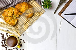 Top view coffee and croissant with coffee bean. Rustic white woo