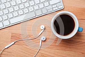 Top view coffee cup earphones and keyboard