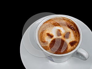 Top view of coffee cup with latte art design on black background