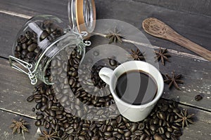 Top view coffee cup with roasted coffee beans in glass jar on rustic wooden table
