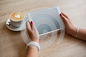 Top view coffee cup and tablet in female hands
