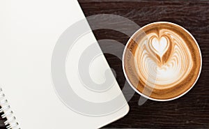 Top view coffee latte art with bank notebook on wood table vintage tone