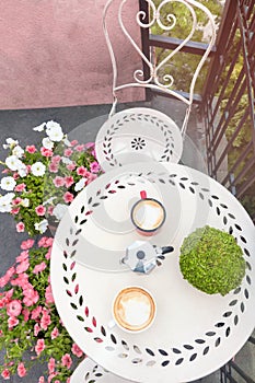 Top view of coffee table with coffee cups on balcony