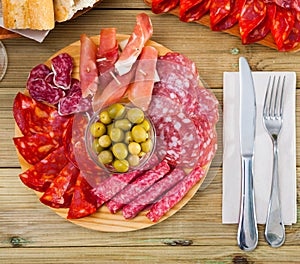 Top view of coldcuts of jamon, sausages on wooden board