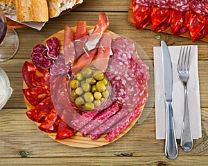 Top view of coldcuts of jamon, sausages on wooden board