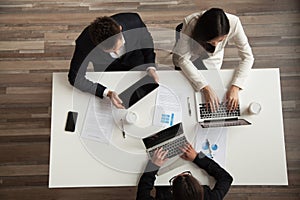 Top view of colleagues working at laptops in office