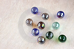 Top view of collection of shiny marbles on wooden background