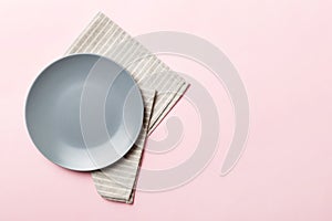 Top view on colored background empty round gray plate on tablecloth for food. Empty dish on napkin with space for your