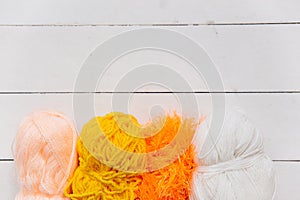 Top view of colored yarn balls and knitting needles