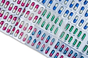 Top view of colorful capsule pills in blister pack arranged with beautiful pattern. Pharmaceutical packaging. Medicine for infecti