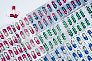 Top view of colorful capsule pills in blister pack arranged with beautiful pattern. Pharmaceutical packaging. Medicine for infecti