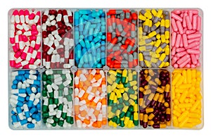 Top view of colorful capsule pills in  plastic box. Antibiotic drugs, painkiller medicine, vitamins, and supplements capsule pills