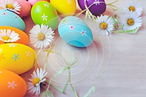 Top view of colorful Easter eggs decorations and dandelions on wooden background