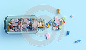 Top view of colorful medical drugs and medicines transparent bottle on light blue backdrop