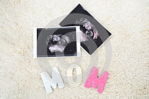 top view of colorful mom word and ultrasound scans of