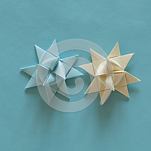 Top view of colorful origami 3D stars on a blue craft paper on the table