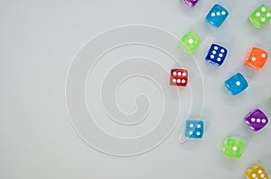 Top view of colorful plastic dice on a gray background with space for text