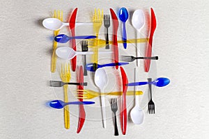 Top view colorful plastic utensils on white background.
