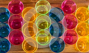 Top view of colorful red, blue, yellow cups on wooden surface