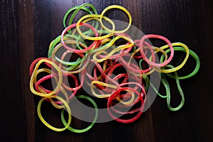 Top view of colorful rubber bands isolated on brown wooden