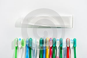 Top view of colorful toothbrushes and tube of toothpaste