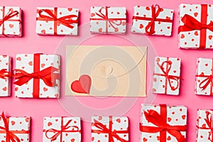 Top view of colorful valentine background made of craft envelope, gift boxes and red textile hearts. Valentine`s Day concept