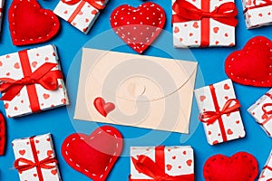 Top view of colorful valentine background made of craft envelope, gift boxes and red textile hearts. Valentine\'s Day concept