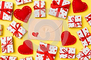 Top view of colorful valentine background made of craft envelope, gift boxes and red textile hearts. Valentine's Day
