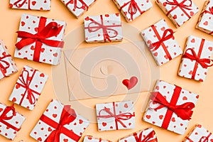 Top view of colorful valentine background made of craft envelope, gift boxes and red textile hearts. Valentine`s Day concept