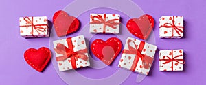 Top view colorful valentine background made of gift boxes and red textile hearts. Valentine\'s Day concept with copy space