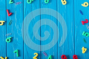 top view of colorful various numbers and paper clips on blue wooden