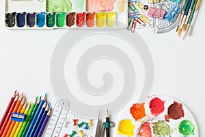 Top view of Colorful Watercolor palette, paintbrush, colored pencils, ruler and drawing equipment  on white background and copy