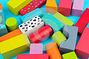 Top view of colorful wooden bricks on the table. Early learning. Educational toys on a blue background