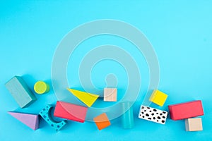 Top view of colorful wooden bricks on the table. Early learning. Educational toys on a blue background