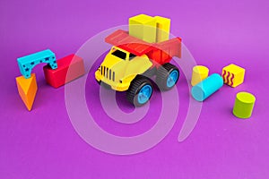 Top view of colorful wooden bricks on the table. Early learning. Educational toys on a purple background