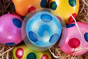 Top view of colourful Easter eggs with polka dots in a basket