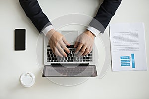 Top view of company CEO typing at laptop