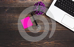 Top view of computer, pink note paper, pencil and flower stock photo