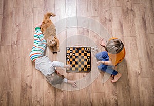 Top view of concentrated child boy developing strategy, playing board game with sister. Preschool kid boy and girl