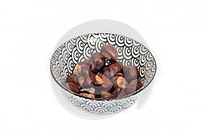 Top view on conkers in black and white design bowl on white studio background