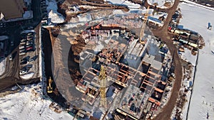 Top view of the construction of a kindergarten. A drone flies over construction cranes. Aerial view