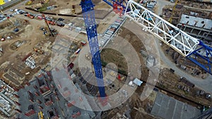 Top view of construction site with crane. Scene. Crane stands above roofs of buildings on construction site with