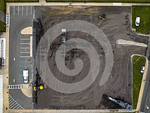 Top view of a construction site with workers on the job, working to re-pave a new parking lot