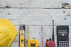 Top view construction tools such as a yellow hard hat, spirit level