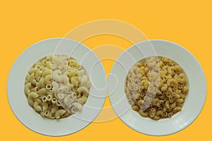 Top view cooked and uncooked macaroni on white round plate and background is bright yellow.