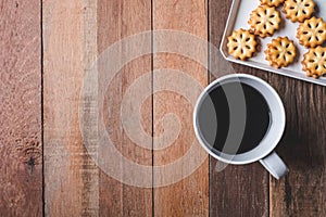 Top view of Cookie and coffee cup on wooden table background.