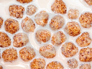 Top view of corn balls floating in milk close up.